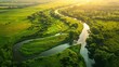 © ktianngoen0128 - Aerial view of a lush green meadow bathed in golden morning light, with a winding river snaking through it