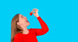 happy curvy woman eating strawberries with open mouth and face up on blue background with copy space Diet and healthy lifestyle 