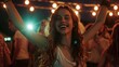Ecstatic young woman dancing at a party with her arms in the air
