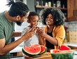 © Lumos sp - child family kitchen food boy son father mother watermelon fruit slice summer organic meal fun preparing healthy diet eating home black