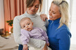 Happy lesbian couple having tender moment with baby at home - Mothers and toddler - LGBT and family concept