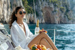 © Володимир Кучмійов - Photo of an elegant woman in sunglasses with fruits and champagne at sea on a yacht