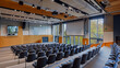 A university lecture hall filled with tiered seating and a large projection screen for presentations.