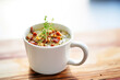 seafood soup with bacon pieces and thyme, in a mug