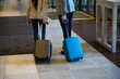 Tourist couple with trolley bags in hotel lobby