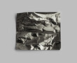 Torn empty crumbled  texture black cellophane foil paper piece on gray background.