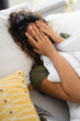 Woman suffering from depression and crying while lying in bed. Woman feeling vulnerable and hopeless covering her face with hands.