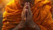 Buddhist monk close up with folded palms praying. A young Buddhist monk
