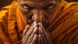 Buddhist monk close up with folded palms praying. A young Buddhist monk