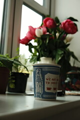 We are happy to serve you coffee cup in front of flowers