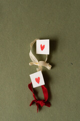 Canvas Print - paper tiles with small red hearts and ring shape cloth ribbon with texture