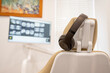 Dentist chair has noise blocker headphones for the patient while reviewing teeth x-rays