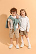 © New Africa - Fashion concept. Stylish children on pale orange background