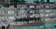Digital composite image of stock market data processing against laptop on office desk