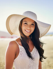 Sticker - A woman in a summer setting, holding a wide-brimmed hat on a sunny beach. The image evokes feelings of relaxation and holiday