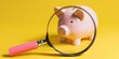 Piggy bank and magnifying glass on yellow background, savings and economy concept