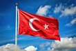 Turkish flag waving against a cloudy and blue sky background