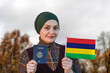 Muslim Woman Holding Passport and Flag of Mauritius
