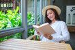 Portrait image of a beautiful young woman with hat reading book
