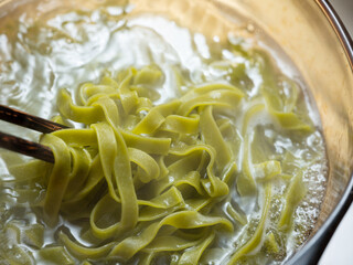 Wall Mural - Spinach pasta boiling in a pot	