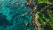 Aerial view of a clear turquoise sea and green grass on a rocky shore in Italy, a beautiful natural background with copy space area for text or design, a top down drone photograph.