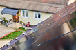 Solar panels installed on sloped roof of suburban home. Panels angled to capture sunlight. Installation of solar batteries on rooftop of house. Concept of alternative energy sources in modern life.
