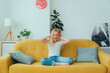 Happy female children listening music wearing headphones sitting on the sofa in the living room - Smiling kid having fun at home - Technology concept