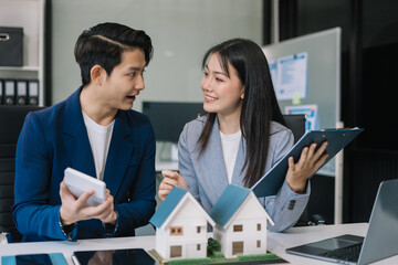 Real estate broker agent presenting and consult to customer to decision making sign insurance form agreement, home model, concerning mortgage loan offer in office.