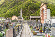 View of the public cemetery in Moghegno, with church of the Beata Vergine Assunta in background, in hamlet of Maggia in the Canton of Ticino, Switzerland
