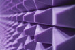 Close perspective of a corner covered in lilac acoustic foam, highlighting the acoustical engineering of a music studio 