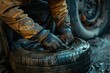 A man is working on a tire, and the tire is dirty. The man is wearing gloves and he is focused on his task