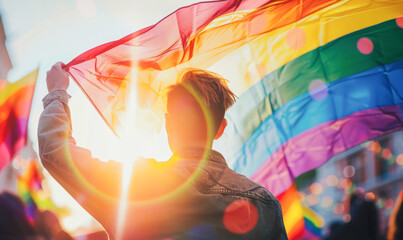 a man holding a rainbow flag in a crowd