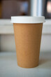 Brown paper cup with white lid of hot coffee 