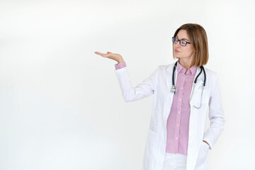 Female doctor standing and pointing on free space isolated on white background