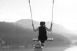© Mats Silvan - Woman on a Swing with Mountain View and Sunlight over Lake Lugano in Morcote, Ticino in Switzerland.