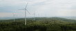 Aerial view of the wind farm between the forest on a overcast day