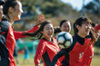 © Surachetsh - An enjoyable atmosphere illustration of a group of women in red and white outfits playing soccer football happily on the local field.