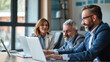 © Perecciv - A group of employees in the office are looking at a laptop and discussing a new business project, collaboration at work, business teams,