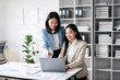© Freedomz - Two women are sitting at a desk with a laptop open