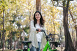 A woman is smiling and riding a green bicycle