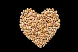 Fototapeta Uliczki - Heart shaped brown beans on black. Flat lay, copy space