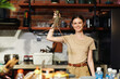 © SHOTPRIME STUDIO - Woman holding up a large lobster in front of sink full of pots and pans in kitchen