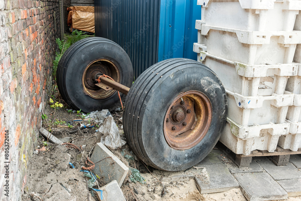 two rubber wheels of a truck connected to each other by a steel beam