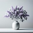 A contemporary vase is filled with lush purple lilac flowers and silver foliage elegantly arranged on a simple gray background