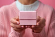 Woman with perfect manicure holding pink gift box in her hands