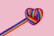 Lgbt rainbow ribbon in a heart shape on bright color background. Gay pride month, coming out day, close up, tolerance concept. Flat lay. top view, place for text or logo