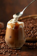 Iced caramel latte topped with whipped cream and caramel sauce.