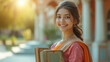 young indian girl college student holding books standing college campus
