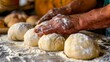 A baker's hands expertly shaping dough into perfectly rounded bread rolls, capturing the artistry and craftsmanship of baking.