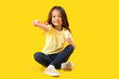 © Pixel-Shot - Cute little girl blowing soap bubbles on yellow background